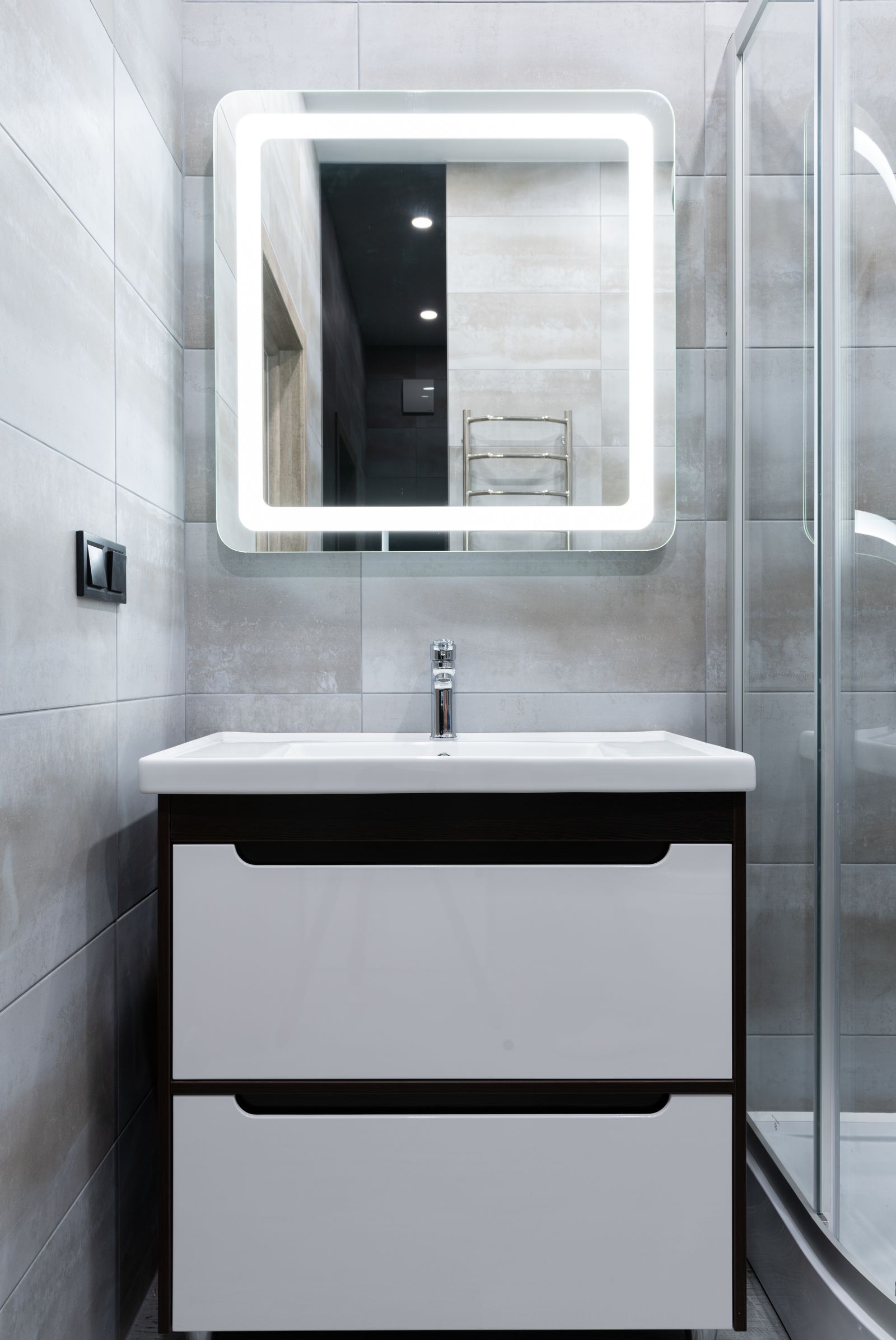 Moderne badkamer met wastafel en verlichte spiegel